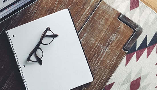 glasses and notebook sitting on table